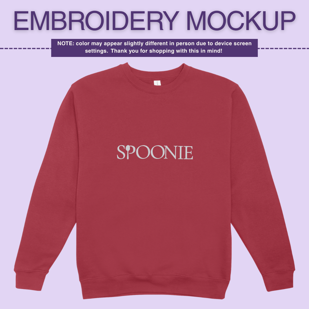 Red sweatshirt with 'SPOONIE' embroidery design on a light purple background