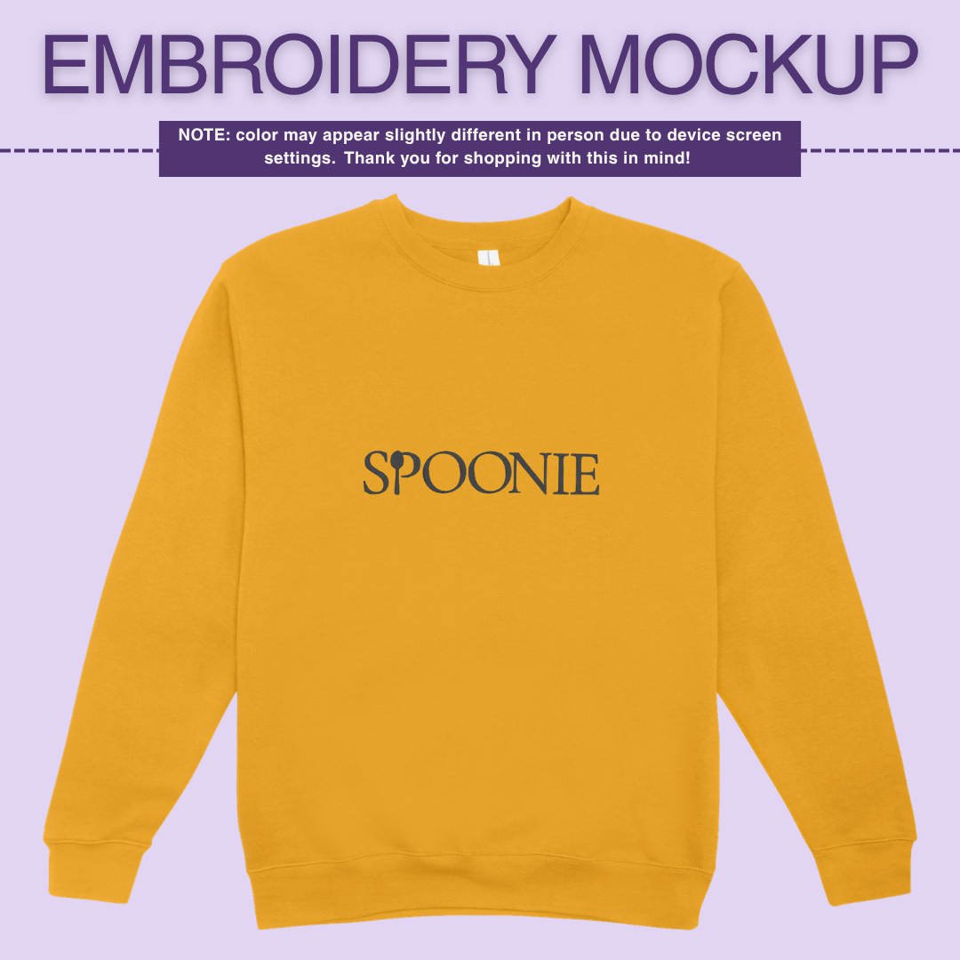 Yellow sweatshirt with 'SPOONIE' embroidery design on a light purple background