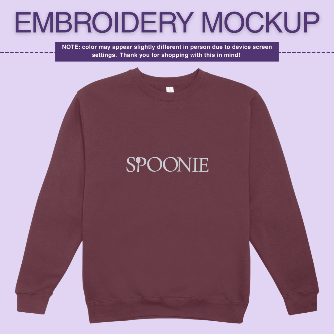 Dark maroon sweatshirt with 'SPOONIE' embroidery design on a light purple background