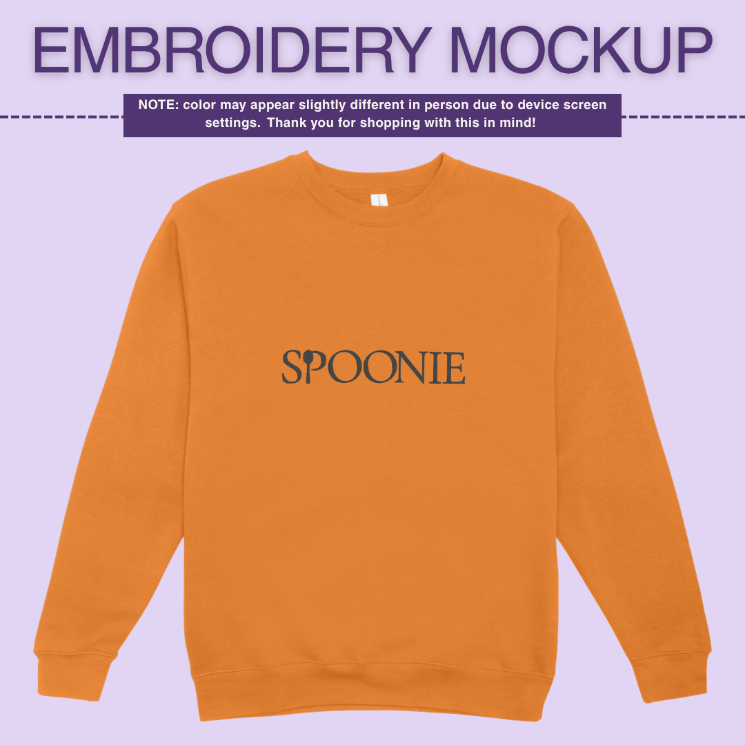 Yellow orange sweatshirt with 'SPOONIE' embroidery design on a light purple background